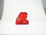 a red figurine sitting on top of a white chair
