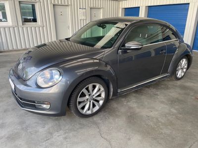 the volkswagen beetle is parked in a garage in front of a blue garage door