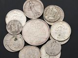 a pile of old coins on a black surface