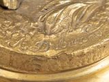 a close up of a gold plate with a bird on it