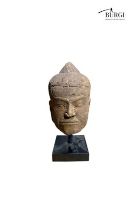 an image of a stone head of a person on a stand