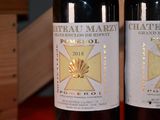 two bottles of wine sitting on a table next to each other