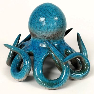 une pieuvre en céramique bleue posée sur une surface blanche