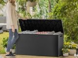 a woman standing next to a black outdoor storage box