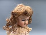 a doll that is wearing a dress with a bow on it