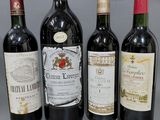 quatre bouteilles de vin sont alignées sur une surface grise
