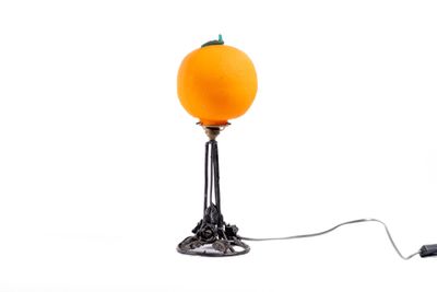 une lampe sur laquelle est posée une orange