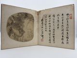 un livre ouvert, sur lequel figurent des caractères chinois, posé sur une table