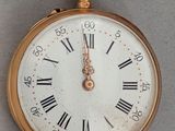 a gold pocket watch with roman numerals on the face