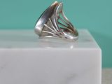 a close up of a silver ring on a marble block