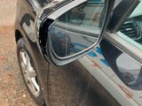 a side view mirror of a car on the side of the road