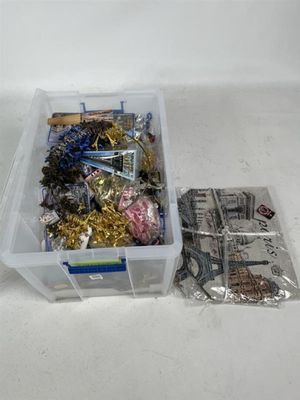 un récipient en plastique rempli d'objets divers posé sur une surface blanche
