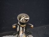 a silver and gold vase with a cigarette in it