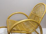 yellow wicker rocking chair on a white surface in a room