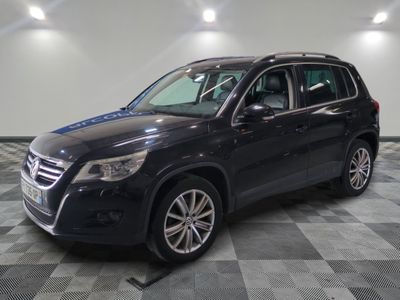 un SUV noir garé sur un sol en carrelage à damier dans un garage