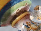 a vase with a colorful design on it sitting on a table