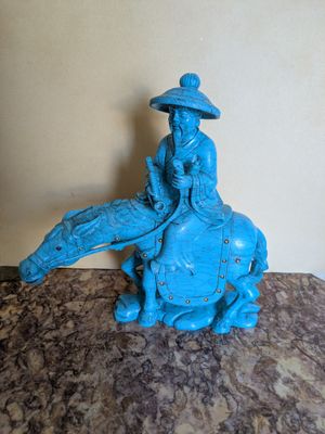 une statue représentant un homme chevauchant un éléphant bleu