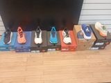 several pairs of shoes lined up on a shelf in front of a tv