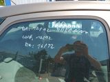 reflection of a man taking a picture of himself in the back window of a car