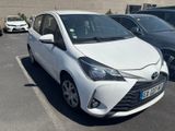 a white toyota yaris parked in a parking lot