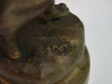 a bronze statue of a person holding a cat