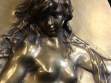 an image of a bronze plaque of a woman holding a knife