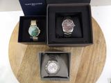two watches and a watch box on a table