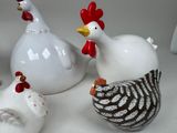 three ceramic chickens sitting next to each other on a table