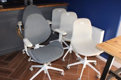 Plusieurs chaises de bureau sont alignées en rang dans une pièce