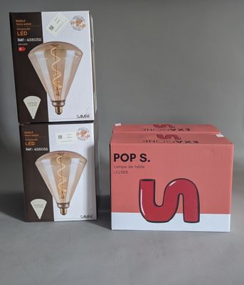 two boxes of light bulbs sitting next to each other on a table