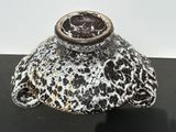 a black and white vase sitting on a black table