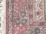 an old rug with fringes on the floor and a cat laying on the floor