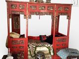 un lit rouge avec une parure de lit à imprimé léopard et un tabouret