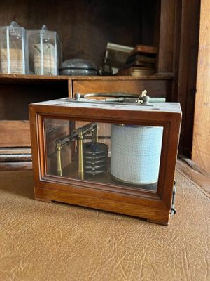 a clock that is sitting on the floor in front of a cabinet