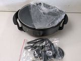 a black pot with a handle and a plastic bag on the table