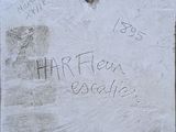 a cement plaque with writing on it on a wall