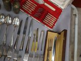 a table with a lot of silverware and silverware on it