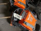 two chainsaws sitting on the ground with a price tag