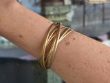 a close up of a person ' s arm with a gold bracelet on it