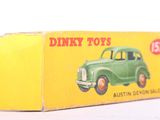 dinky toy car in box on white surface with yellow background