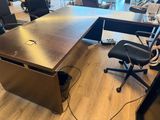 a desk with a chair and a monitor in a room