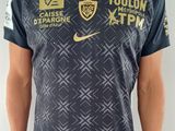 Cet homme pose pour une photo dans son maillot de foot