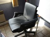 a black office chair sitting in front of a white board