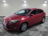 Une Ford Focus rouge est garée dans une pièce dont le sol est en damier.