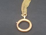 a close up of a gold necklace on a black surface