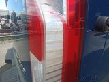 a blue van with a red tail light and a red tail light