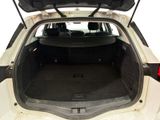 the back of a white car with its trunk open showing the cargo area
