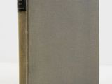 an old book sitting on top of a table next to a white wall