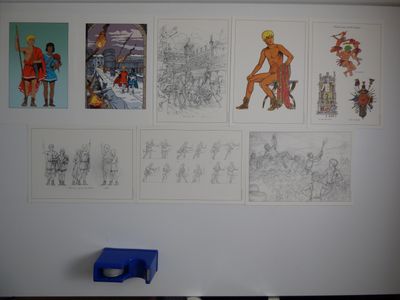 de nombreux tableaux accrochés au mur d'une pièce où se trouve une chaise bleue