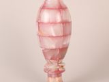un vase en verre rose orné d'un motif en spirale